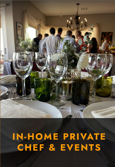 Elegant table set with glassware, white plates, and floral centerpiece at a cozy in-home private chef event gathering.
